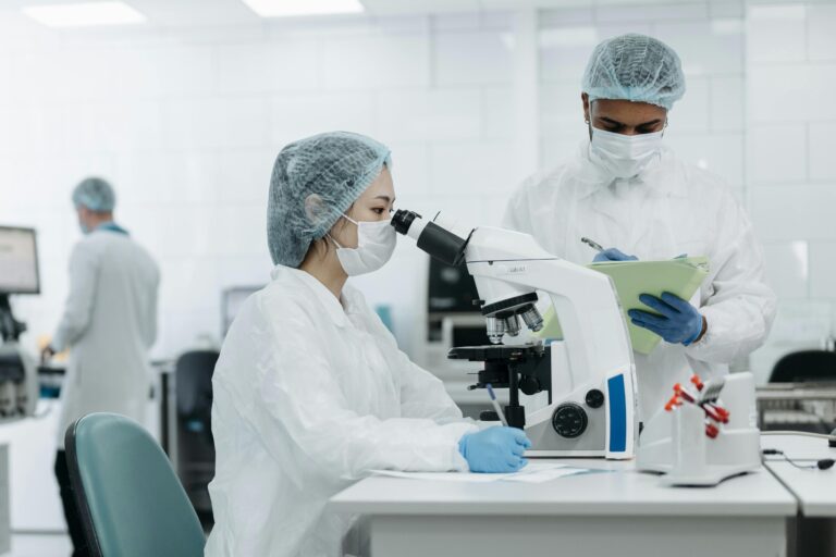 Lab - woman - Pex-woman-in-white-protective-suit-looking-through-microscope-8442099